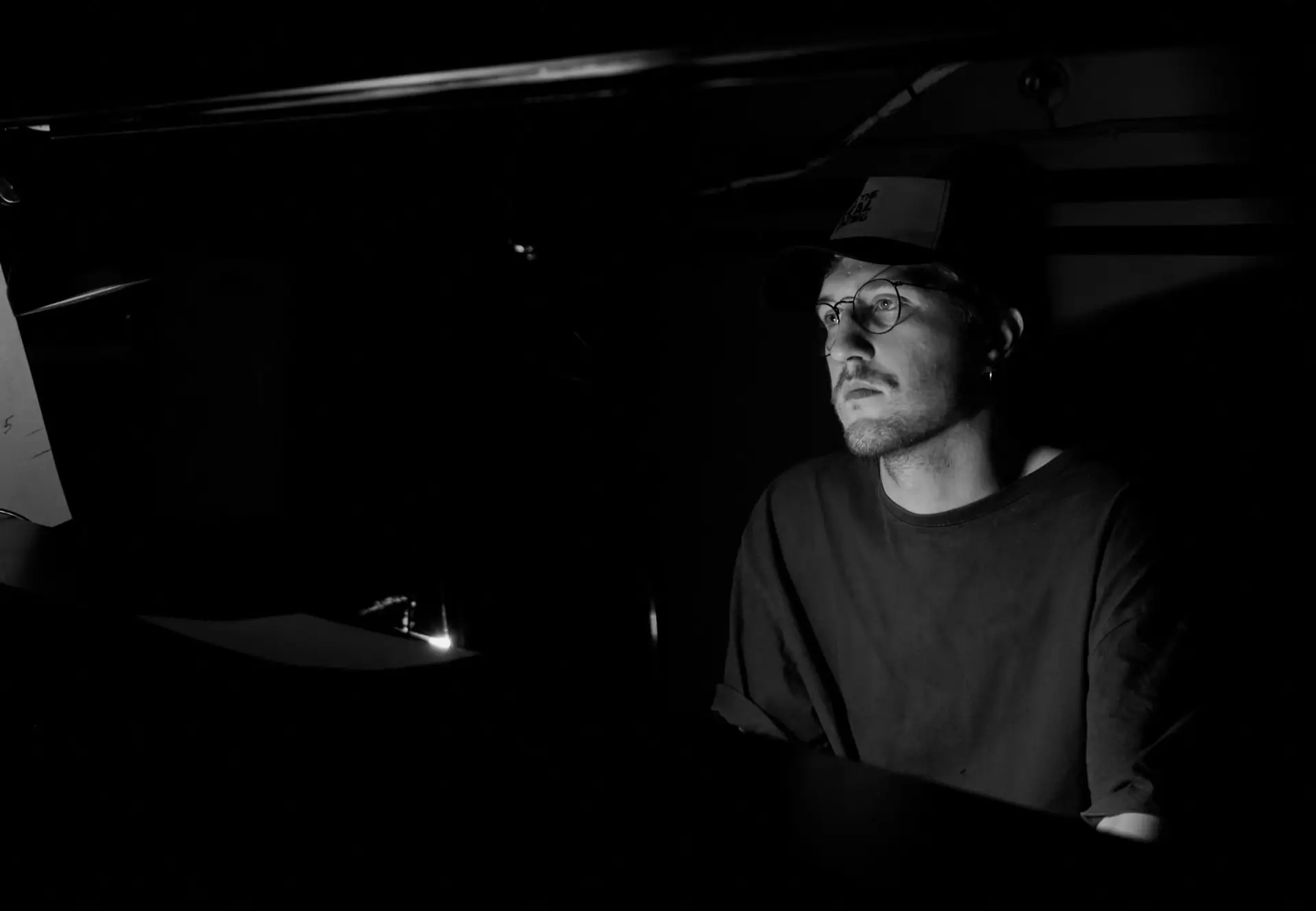 Basilio Utekhin at a technical desk, lit by a monitor